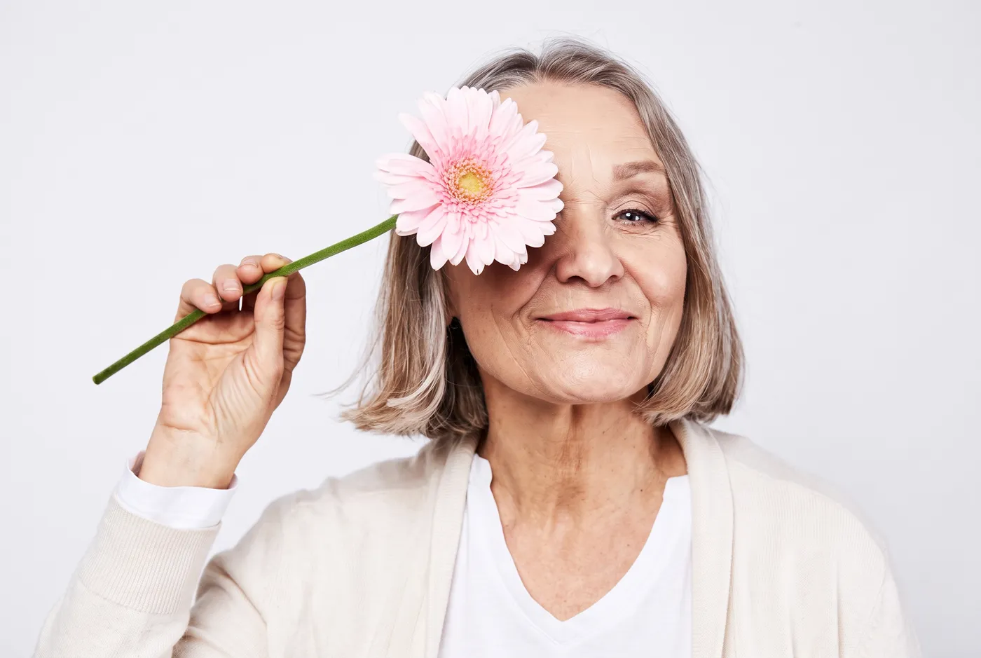 Mujer sonriente con una flor rosa · Consulta de perimenopausia y menopausia en Córporal Barcelona